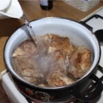w dużym garnku gotują się kawałki żeberek wieprzowych