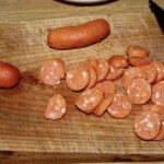 pokrojone w plasterki kiełbaski debreczynki na desce kuchennej
