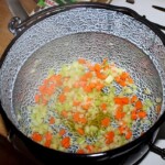 w dużym garnku smażą się drobno pokrojone warzywa