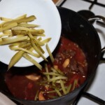 karkówka z dzika gotuje się w garnku i wrzucana jest do niej pokrojona w paski kolorowa papryka oraz tak samo pokrojone ogórki kiszone