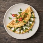 Omlet ze szparagami przyrządzamy zawsze ze świeżych wiejskich jajek. Rozkłócone jajka należy połączyć na patelni z kawałkami jędrnych zielonych szparagów oraz serem feta i ostrą papryczką chilli.