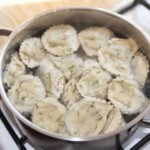 pierogi z dorszem i speckiem gotują się w garnku z wodą