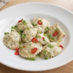 pierogi z dorszem i speckiem podane na talerzu