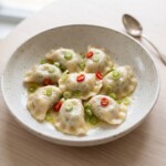 pierogi z dorszem i speckiem podane na talerzu