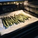 zielone szparagi na blasze do pieczenia pieką się w piekarniku