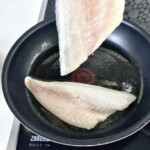 nas patelni smażą się dwa filety z dorady