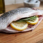dorada wypełniona plastrami cytryny oraz świeżym rozmarynem