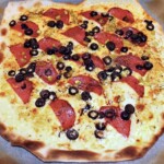 flammkuchen podpłomyk z salami, oliwkami i jalapeno