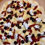 flammkuchen podpłomyk z fetą, salami i oliwkami