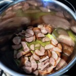 w garnku smażą się plasterki kiełbasy