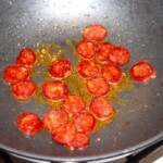 na patelni smażą się plasterki kiełbasy chorizo