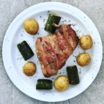 Królik pieczony w boczku i z warzywami