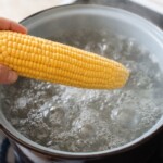 kolba kukurydzy wkładana jest do garnka z gotującą się wodą