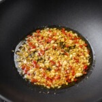 w woku na oliwie smaży się siekany czosnek i chilli