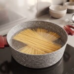 w dużym garnku w wodzie gotuje się makaron spaghetti