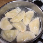 pierogi z bobem, bryndzą i świeżą miętą gotują się w wodzie w garnku