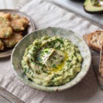 puree z awokado ziemniaków i oliwy w miseczce obok talerz z eskalopkami i kromkami chleba