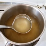 w garnku przygotowany jets bulion do przyrządzenia risotto z cukinią