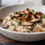 risotto z grzybami leśnymi podane w głębokim talerzu