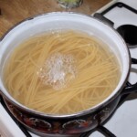 w dużym garnku gotuje się w wodzie makaron spaghetti