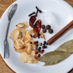przyprawy na talerzyku: laska cynamonu, chilli, kolorowy pieprz, suszony czosnek, suszone chilli, kulki ziela angielskiego