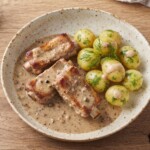 żeberka wieprzowe duszone z czosnkiem i chilli podane na talerzu z gotowanymi ziemniakami