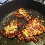 mięso z udek kurczaka posypane sezamem smaży się na patelni