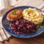 buraki czerwone zasmażane podane na talerzu z kotletem mielonym oraz ziemniakami puree