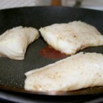 na patelni smażą się duże kawałki polędwicy z dorsza