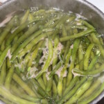 w garnku gotuje się zielona fasolka szparagowa