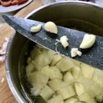 w garnku znajdują się obrane i pokrojone w mała kostkę ziemniaki