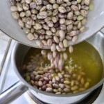 fasola borlotti wrzucana jest do garnka z wywarem