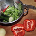 pokrojona na pół czerwona papryka, groszek cukrowy oraz kawałek cukinii