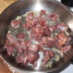 na dużej patelni smaży się pokrojona w nieduża kostkę wieprzowina na gulasz