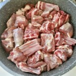 kawałki jagnięciny z kością smażą się na patelni