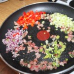 na patelni smażą się drobno siekane warzywa