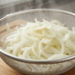 pokrojona w piórka cebula odcieka na sicie