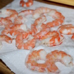 obrane i umyte krewetki susza się na ręczniku papierowym