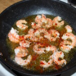 obrane krewetki smażą się na patelni na oliwie