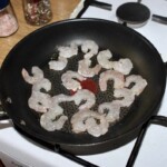 na patelni smażą się obrane krewetki koktajlowe