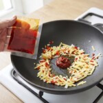 w woku smaży się pasta curry razem z siekanym chilli, czosnkiem i imbirem