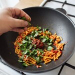 w woku smaży się pasta curry razem z siekanym chilli, czosnkiem i imbirem