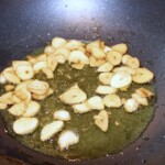 w garnku na oliwie smażą się obrane ząbki czosnku