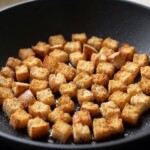 chleb pokrojony w małe kosteczki smaży się na grzanki na patelni