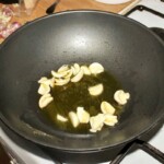 na patelni smażą się obrane ząbki czosnku