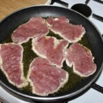 plastry polędwiczki wieprzowej smażą się na patelni