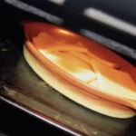w naczyniu żaroodpornym w piekarniku smaży się ser raclette