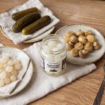 raclette z ziemniakami gotowanymi i kiszonkami w trakcie przygotowania