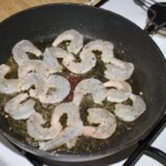 na patelni smażą się obrane krewetki koktajlowe