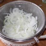 odcedzona na durszlaku cebula pokrojona w piórka